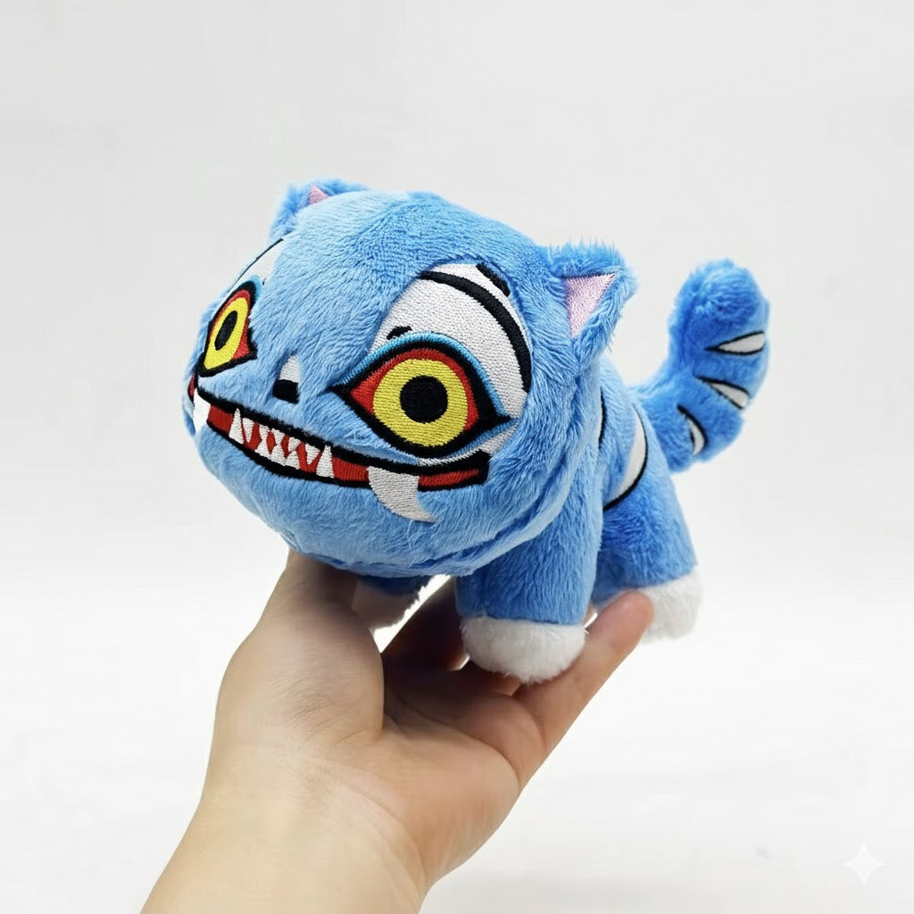 Blue plush toy with a cartoonish face held in a hand against a white background